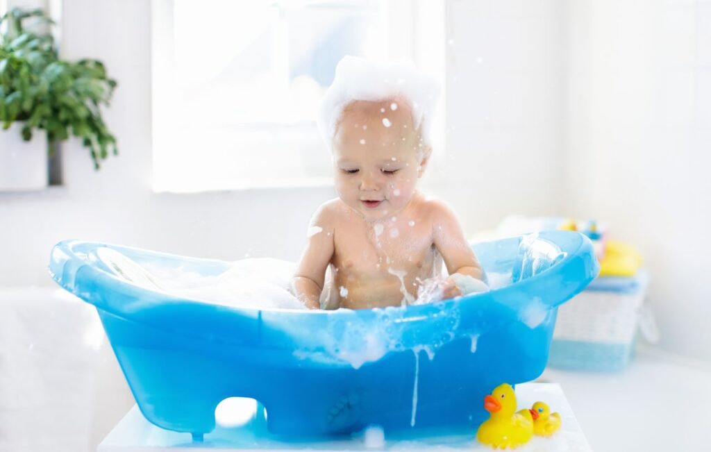 Happy baby playing with Disney bath toys